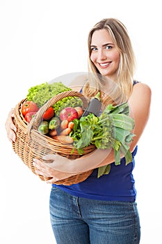 Young healthy beautiful woman with a basket full of fresh vegetables
