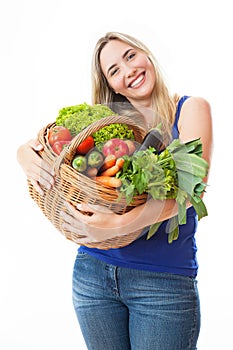 Young healthy beautiful woman with a basket full of fresh vegetables