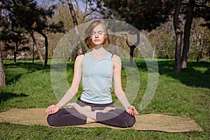 Young healthy caucasian woman doing yoga fitness exercise at Park.