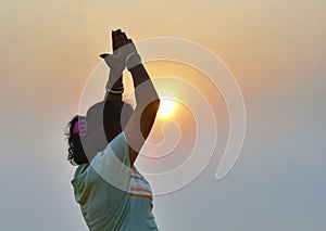 Young healthy Indian woman workout yoga pose on the beach at sunrise, benefits of natural environments for physical, spiritual,