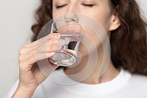 Young healthy woman drinking glass of fresh pure filtered water.