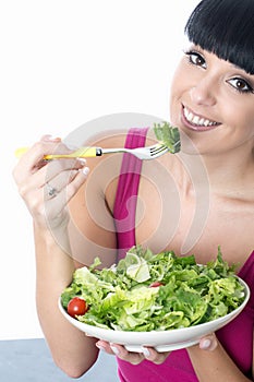 Young Healthy Woman Eating a Fresh Bowl of Green Salad Leaves