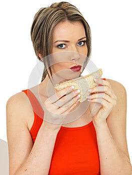 Young Healthy Woman Eating a Salmon and Cucumber Brown Bread Sandwich