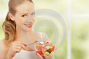 Young healthy woman eats vegetable salad