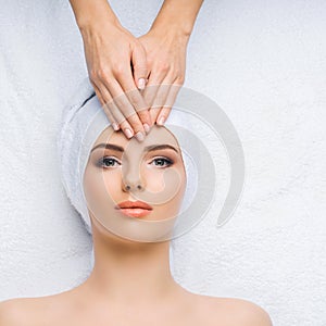 Young and healthy woman gets massage treatments for face, skin and neck in the spa salon. Health, wellness and
