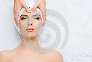 Young and healthy woman gets massage treatments for face, skin and neck in the spa salon. Health, wellness and