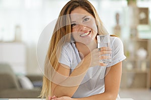 Young healthy woman holding glass water