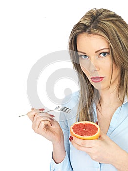 Young Healthy Woman Holding a Pink Grapefruit