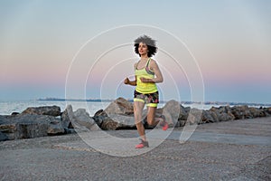 Young healthy woman jogging along the beach