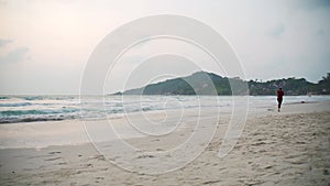 Young healthy woman jogging at the beach at the sunrise time.