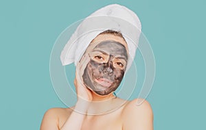 Young healthy woman in spa making treatments and face mask. Beautiful woman with cosmetic mud facial procedure, spa