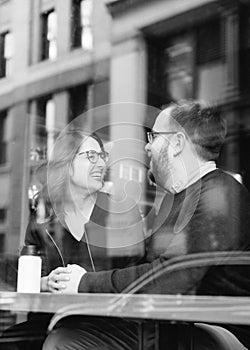 A young heterosexual couple enjoying a conversation at a nyc coffee shop