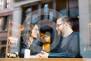 A young heterosexual couple enjoying a conversation at a nyc coffee shop