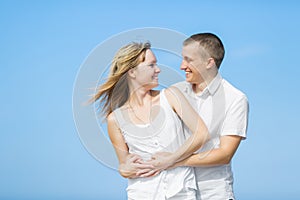 Young heterosexual couple posing against the sky