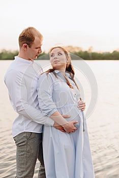 Young heterosexual pregnant couple in an outdoor park