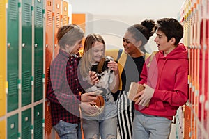 Young high school students meeting and greeting near locker in campus hallway, back to school concept.