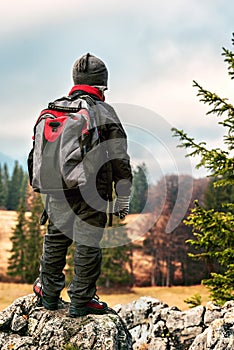 Young hiker with backpack on peak