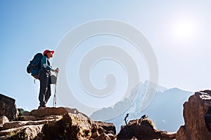 Young hiker backpacker female on cliff edge enjoying the Thamserku 6608m mountain during high altitude Acclimatization walk. photo