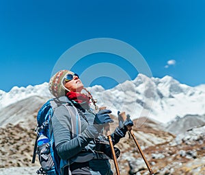 Young hiker backpacker female taking brake in hike walking during high altitude Everest Base Camp EBC route with snow Himalayan photo