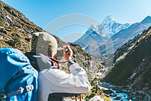 Young hiker backpacker female taking photo mountain view during high altitude Acclimatization walk. Everest Base Camp trekking