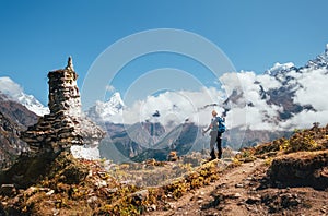 Young hiker backpacker man with trekking poles enjoying the Ama Dablam 6814m peak mountain during acclimatization walk near