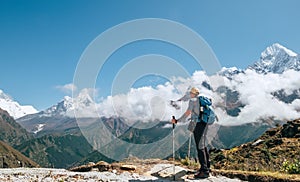 Young hiker backpacker man with trekking poles enjoying the Ama Dablam 6814m peak mountain during high altitude acclimatization