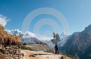 Young hiker backpacker man with trekking poles enjoying the Ama Dablam 6814m peak mountain during high altitude acclimatization photo