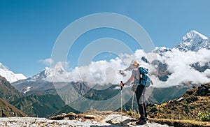 Young hiker backpacker man with trekking poles enjoying the Ama Dablam 6814m peak mountain during high altitude acclimatization photo