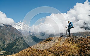 Young hiker backpacker man using trekking poles enjoying the Nuptse 7861m mountain during high altitude Acclimatization walk.