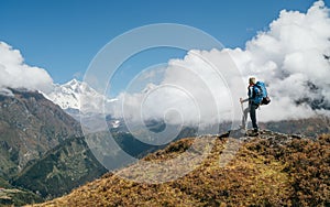 Young hiker backpacker man using trekking poles enjoying the Nuptse 7861m mountain during high altitude Acclimatization walk. photo