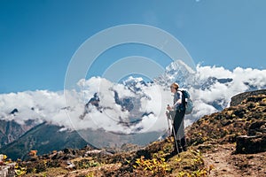 Young hiker backpacker man using trekking poles enjoying the Thamserku 6608m mountain during high altitude Acclimatization walk.