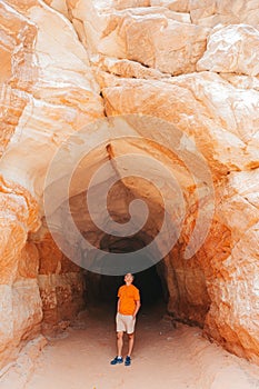Young hiker man on popular trail Belly of the Dragon Tunnel Cave in Kanab