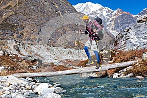 Young Hiker passing Mountain Creek on wood Bridge