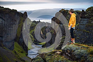 Young hiker standing at the edge of the Fjadrargljufur Canyon in Iceland