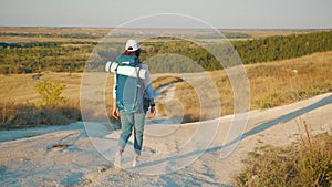 Young hiker woman with a backpack on top mountains at sunset. Lifestyle, travel concept.