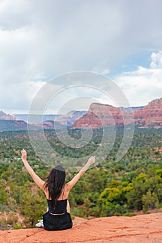 Young hiker woman on the edge of a cliff at Cathedral Rock in Sedona, Arizona. View from Scenic Cathedral Rock in