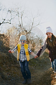 Young hikers, pre-schooler, girls and boys, wearing casual cold-weather attire in sunny forest adventure. Outdoor