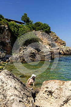 Young hippie beautiful nudist woman on the sea shore in summer time having relaxing time in water on o sunny day