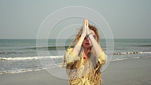 A young hippie woman is dancing on the beach. Hipster girl with dreadlocks