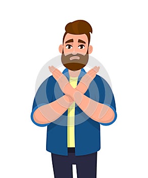 Young hipster bearded man crossing arms and saying no gesture. Person making X shape, stop sign with hands and negative expression