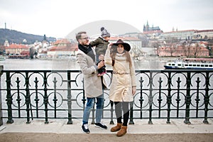 Young hipster couple with baby walking old town streets