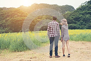 Young hipster couple taking a walk on beautiful flower field.