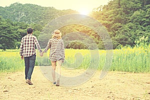 Young hipster couple taking a walk on beautiful flower field.