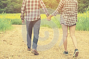 Young hipster couple taking a walk on beautiful flower field.