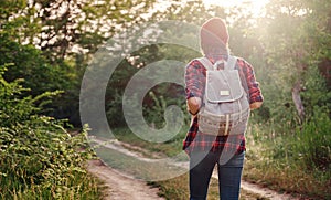 Young hipster girl enjoy sunset. Travel woman with backpack