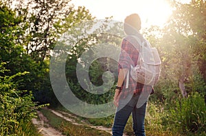 Young hipster girl enjoy sunset. Travel woman with backpack