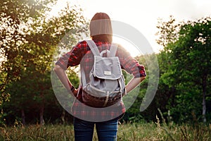 Young hipster girl enjoy sunset. Travel woman with backpack