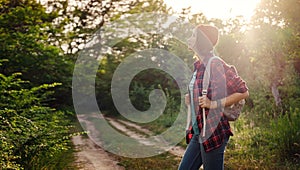 Young hipster girl enjoy sunset. Travel woman with backpack