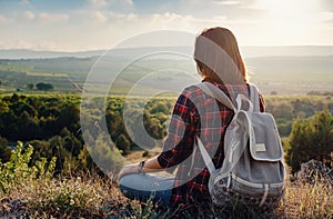 Young hipster girl enjoy sunset on viewpoint. Travel woman with backpack