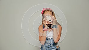 Young hipster girl holding retor insta polaroid camera taking photo portrait